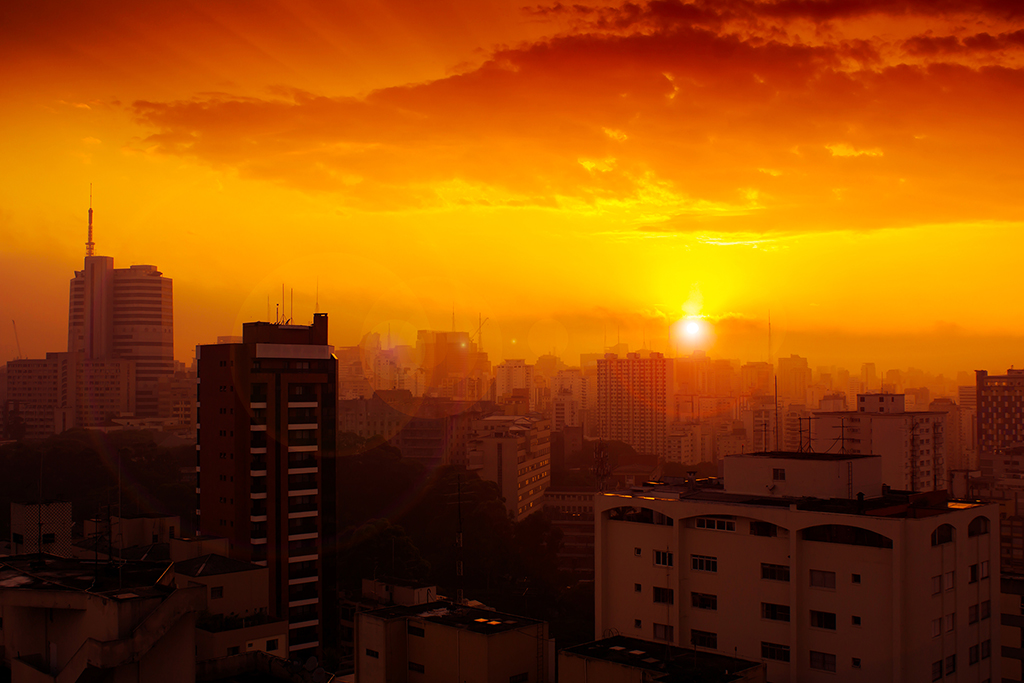 Golden hues paint the sky as the sun sets over the sprawling cityscape of São Paulo, Brazil, casting a warm glow over the urban jungle. São Paulo, Brazil